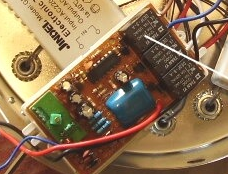 Точный фрагмент исходного фото: открытая плата с чёрными реле, синим корпусом компонента, проводами и частью соседнего трансформатора.